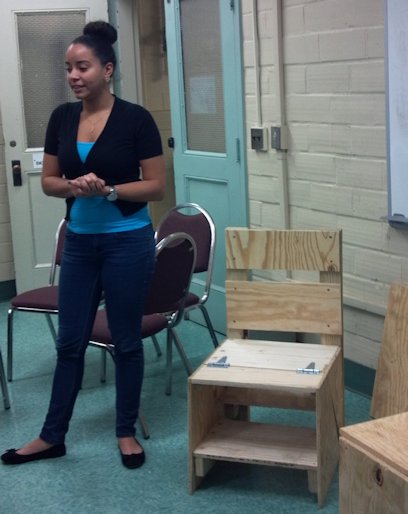 URI Honors class presenter discussing how the box becomes a chair becomes a table becomes a stool.